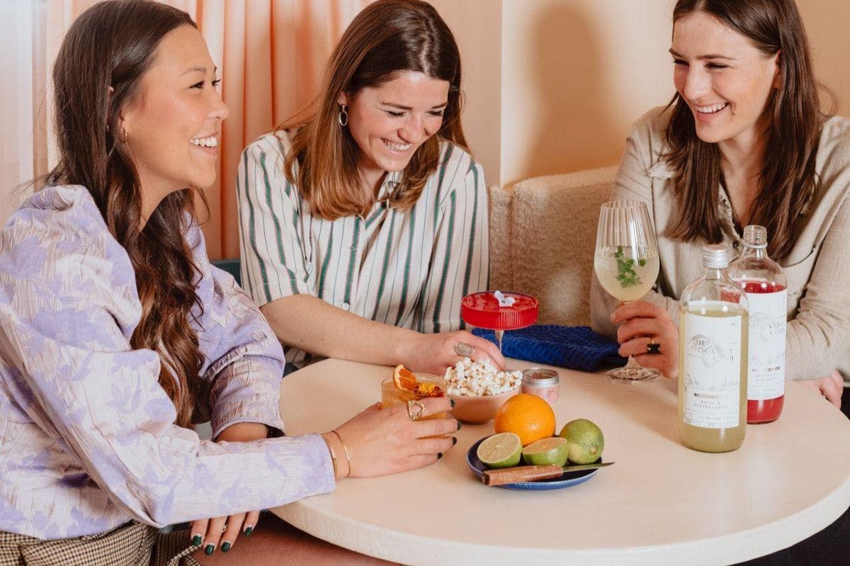 Women laughing while drinking mocktails