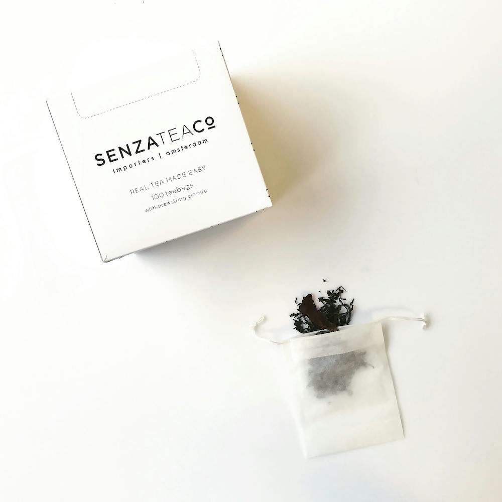 Carton box with Senza Tea logo and tea leaves in tea filter